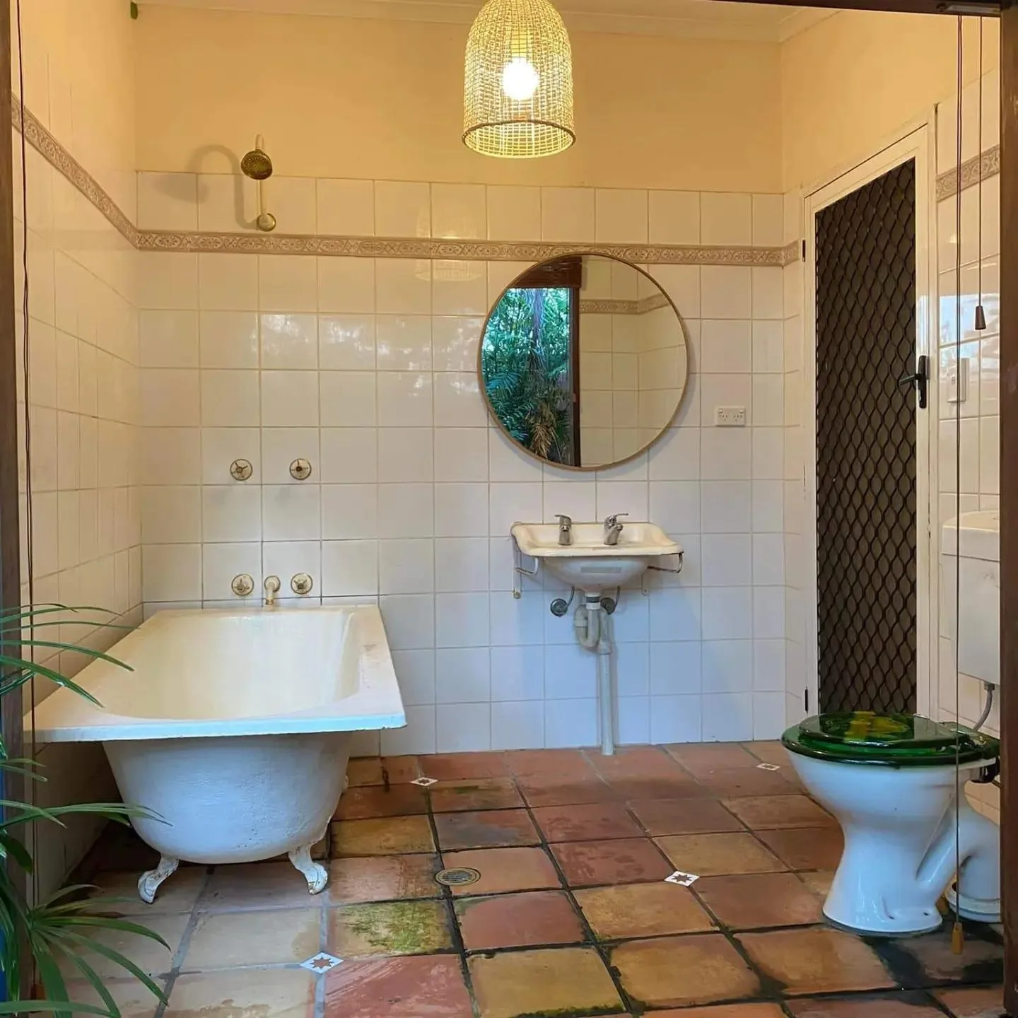 Before: Sage-tiled bathroom with a curbless glass shower, floating timber vanity and stone vessel sink