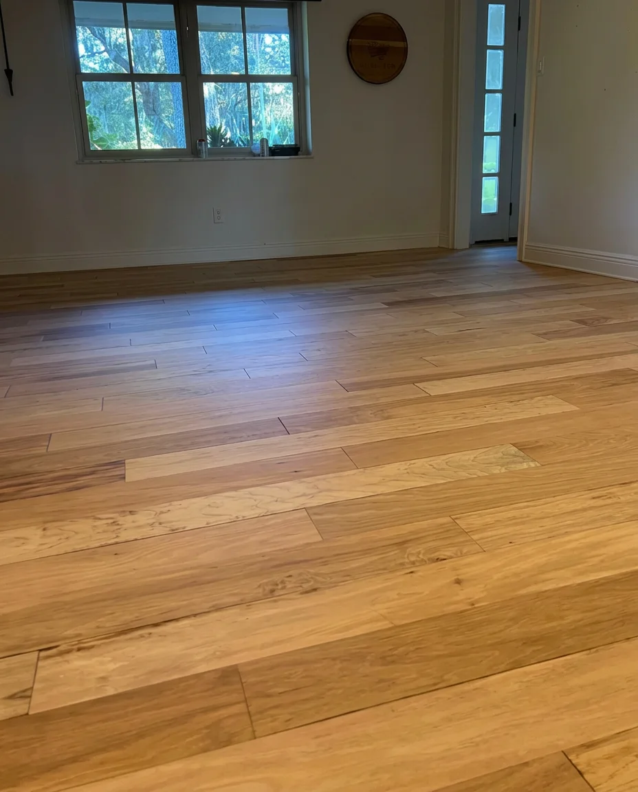 Renown hardwood floor refinishing: freshly refinished light wood planks in a sunlit room
