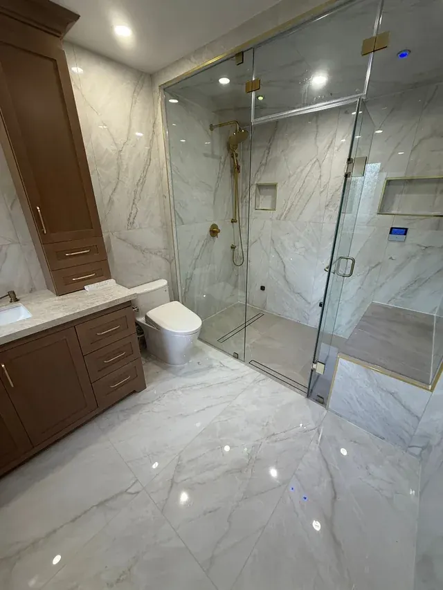 After: Marble-look bathroom with full-height glass steam shower
