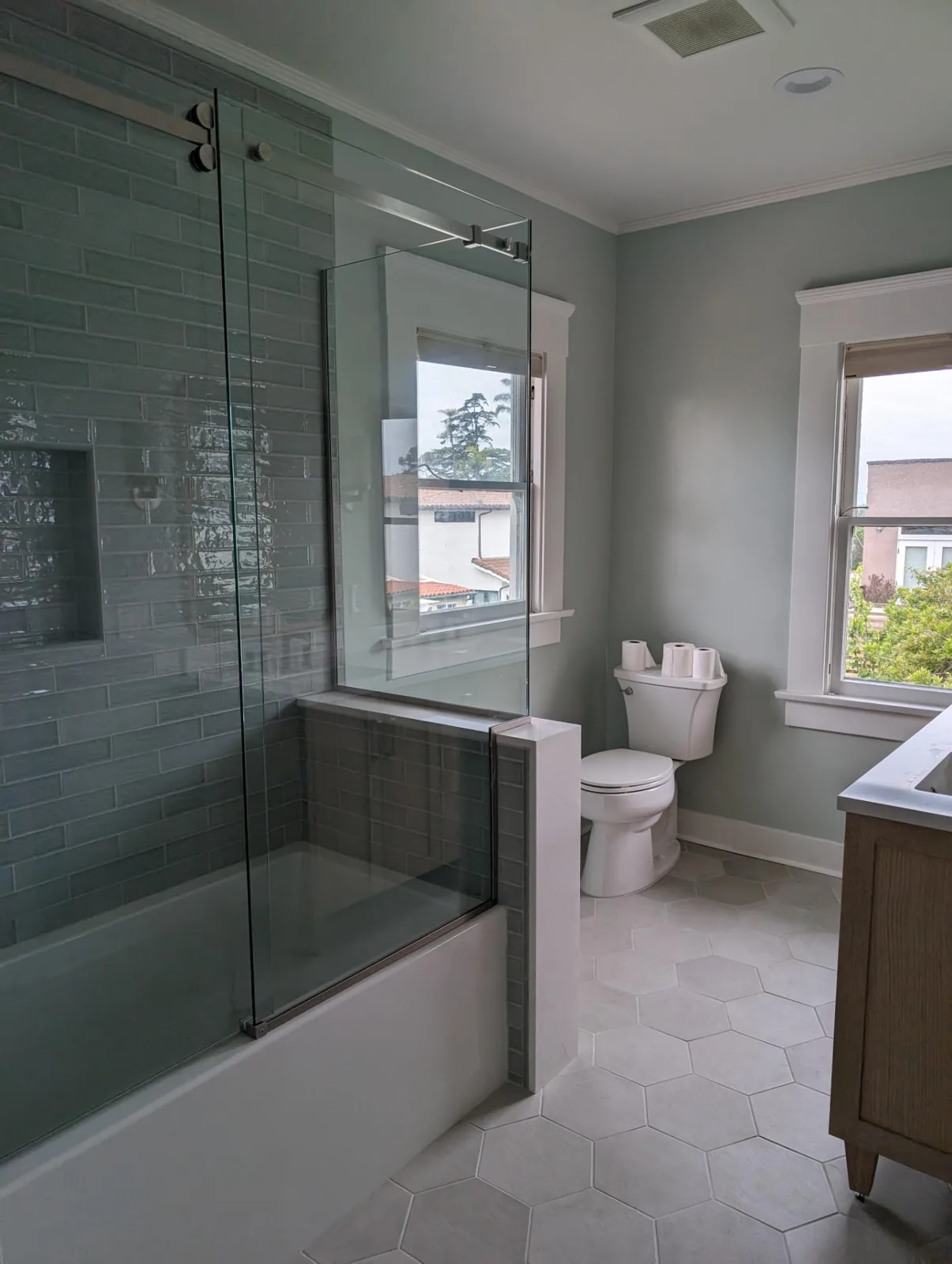 After: Craftsman-home bathroom with a glass tub-shower in sage subway tile and hexagon floor