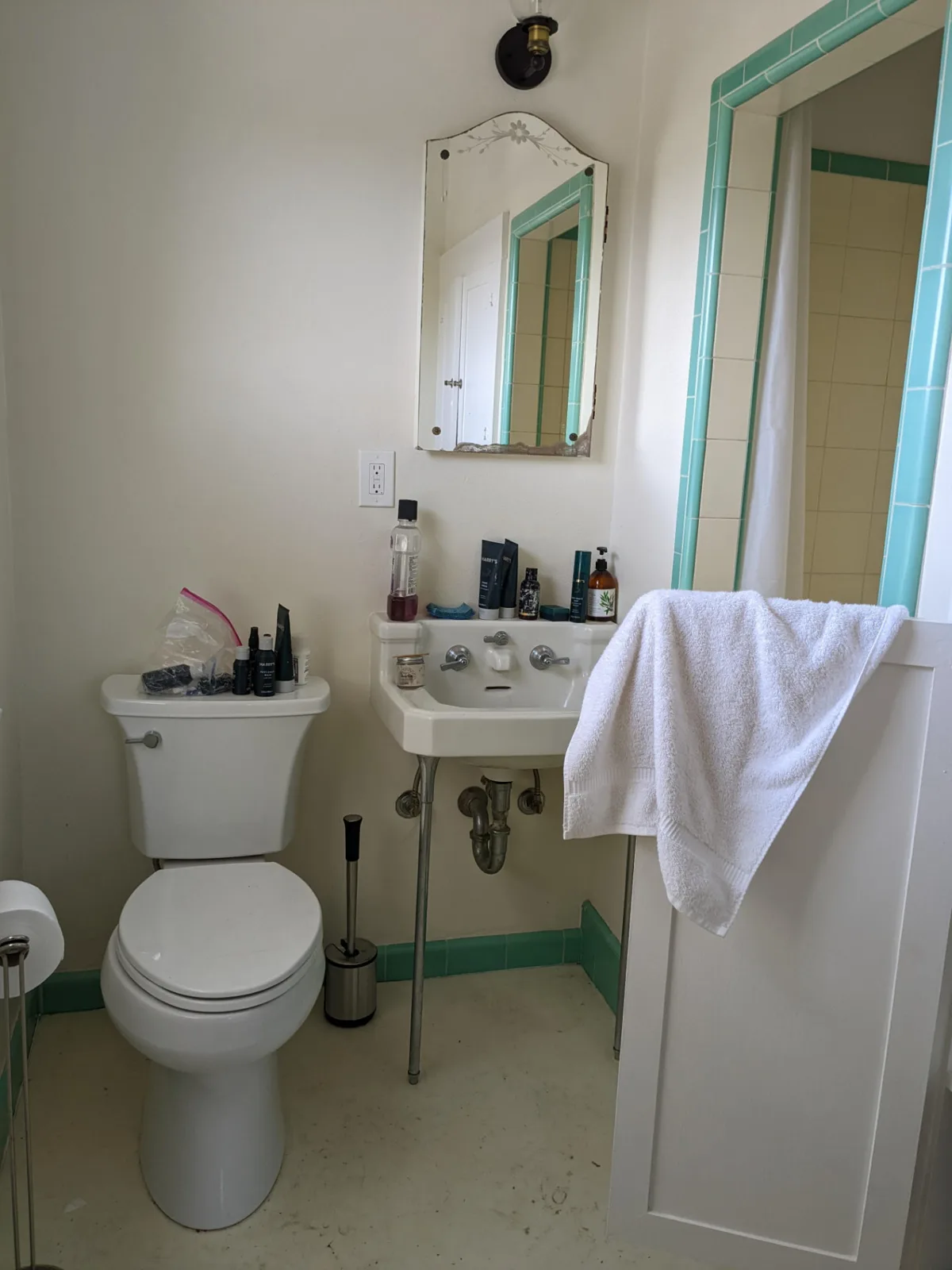 Before: Craftsman-home bathroom with a dark hex-tile glass shower and mid-century wood double vanity