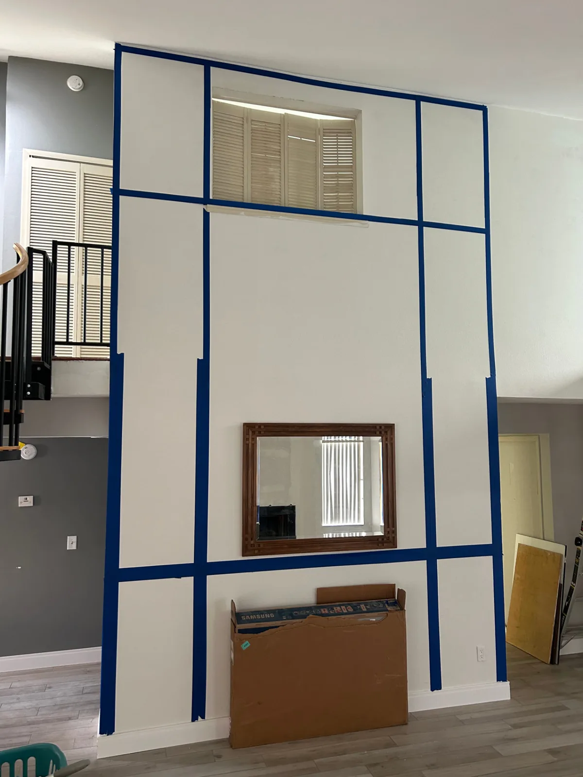Before: Two-story living room wall with charcoal grid-panel trim