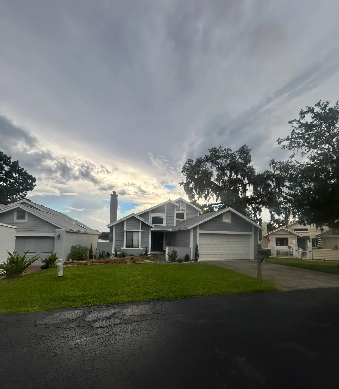 Finished: Finished home exterior with new gray siding, white trim and white garage door