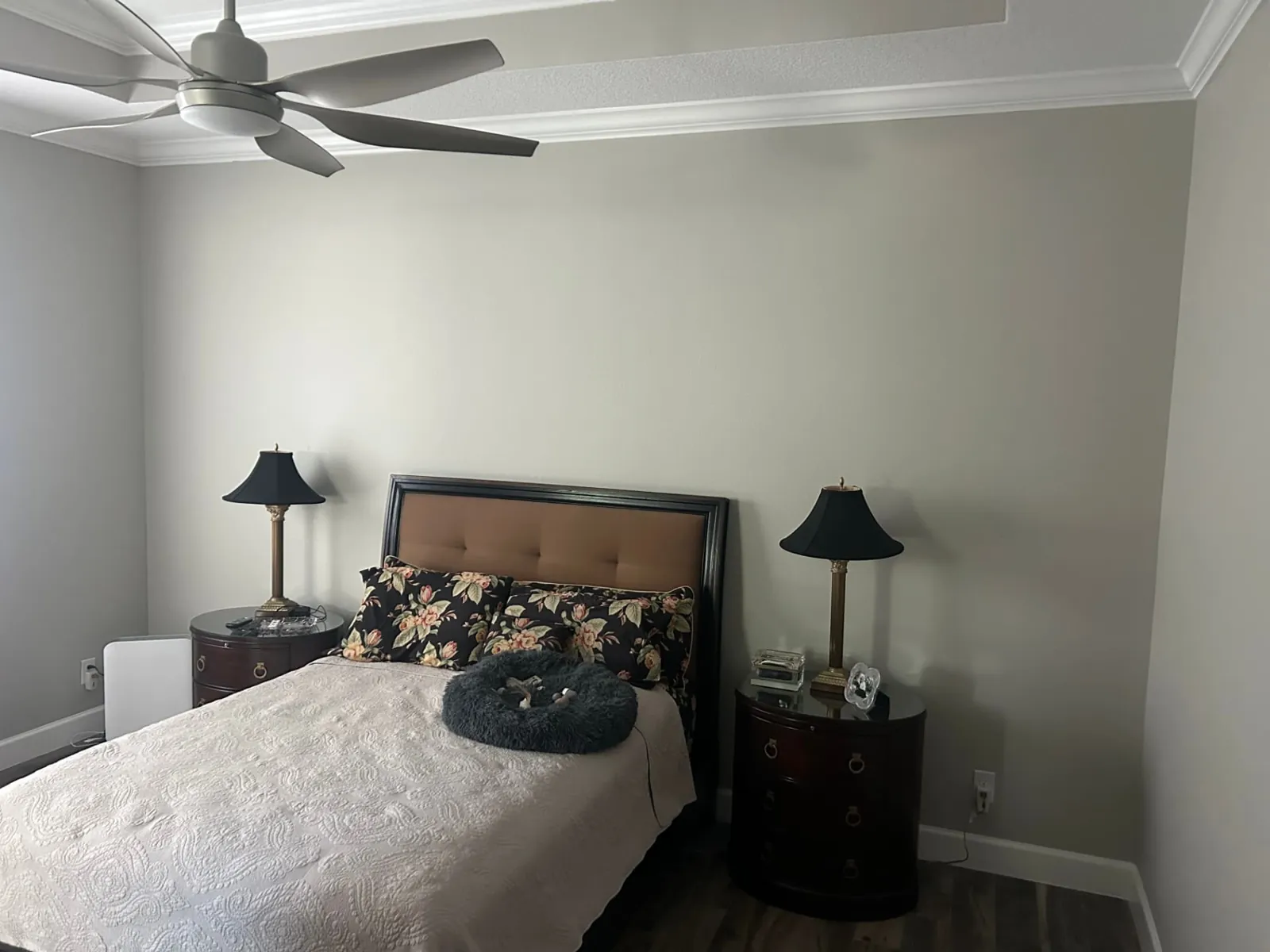 Before: Bedroom with a full-height white grid-panel accent wall behind the bed
