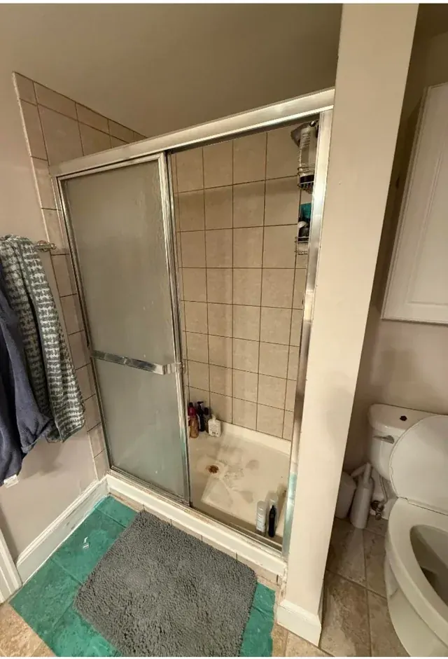 Before: Primary bathroom with fluted-tile shower
