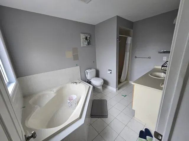 Before: Marble-look bathroom with full-height glass steam shower