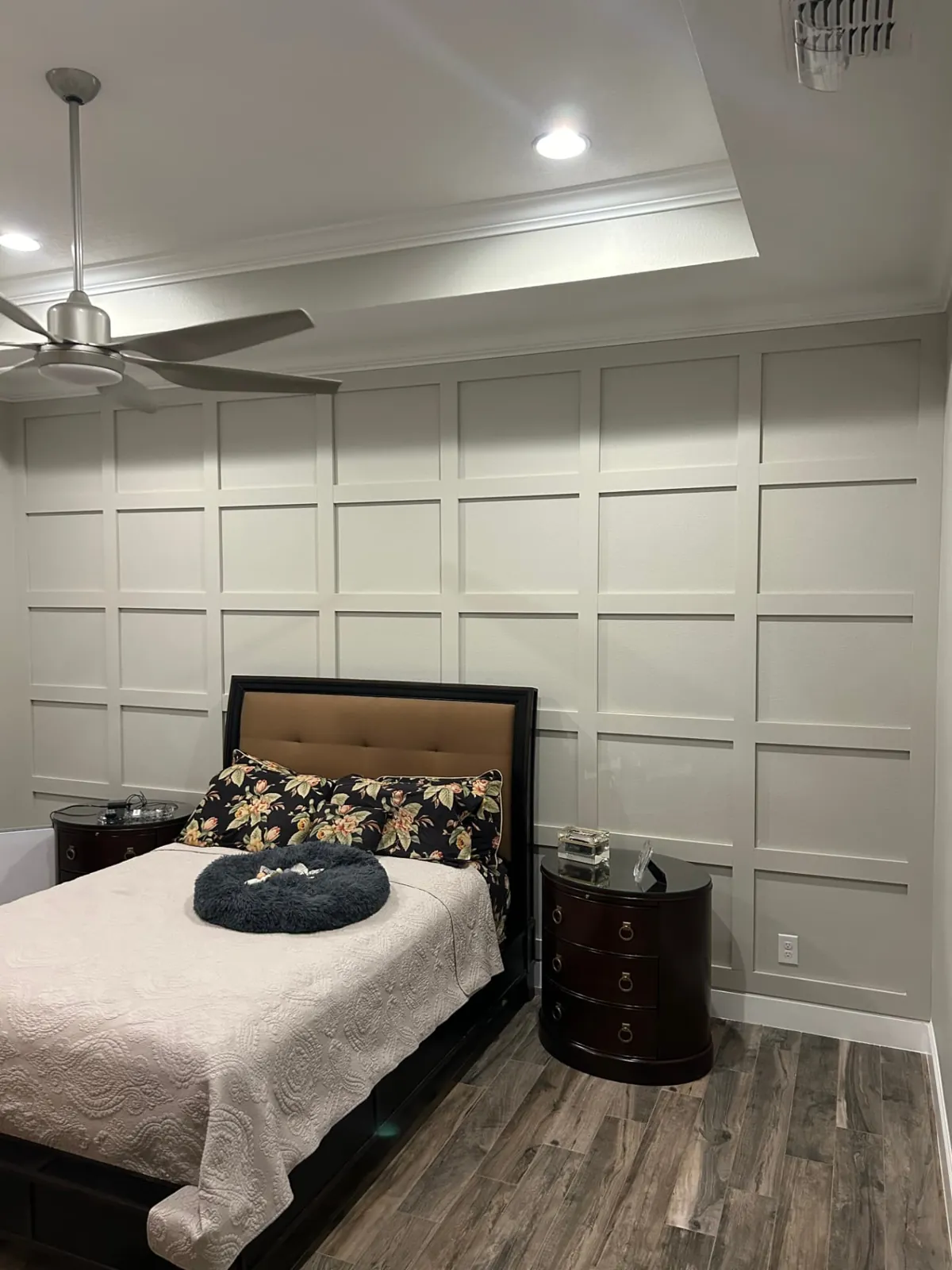 After: Bedroom with a full-height white grid-panel accent wall behind the bed